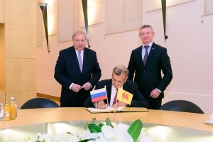 M. Stepan Zhiryakov signe le livre d’or du Parlement sous les regards de son collègue M. Oleg Kazakovtsev et du Président Antoine